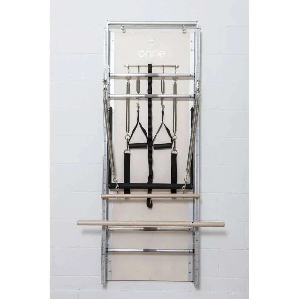 Vue frontale Pilates Wall Unit 5-en-1 avec deux barres horizontales en bois, sangles noires et panneau beige logo onnes